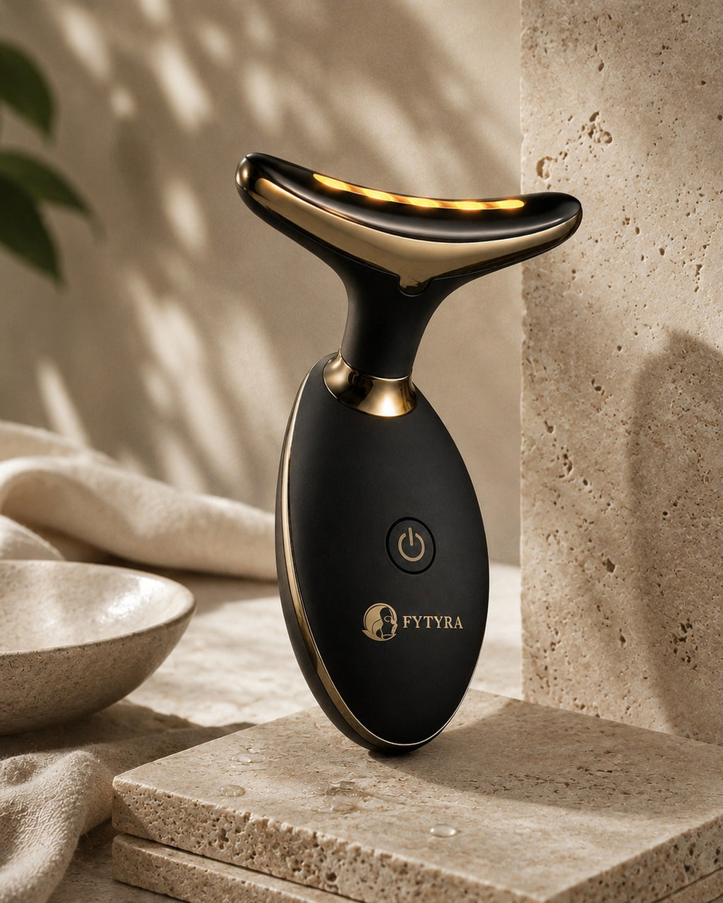 The Fytyra Sculpting Device in Midnight on a travertine ledge in warm daylight