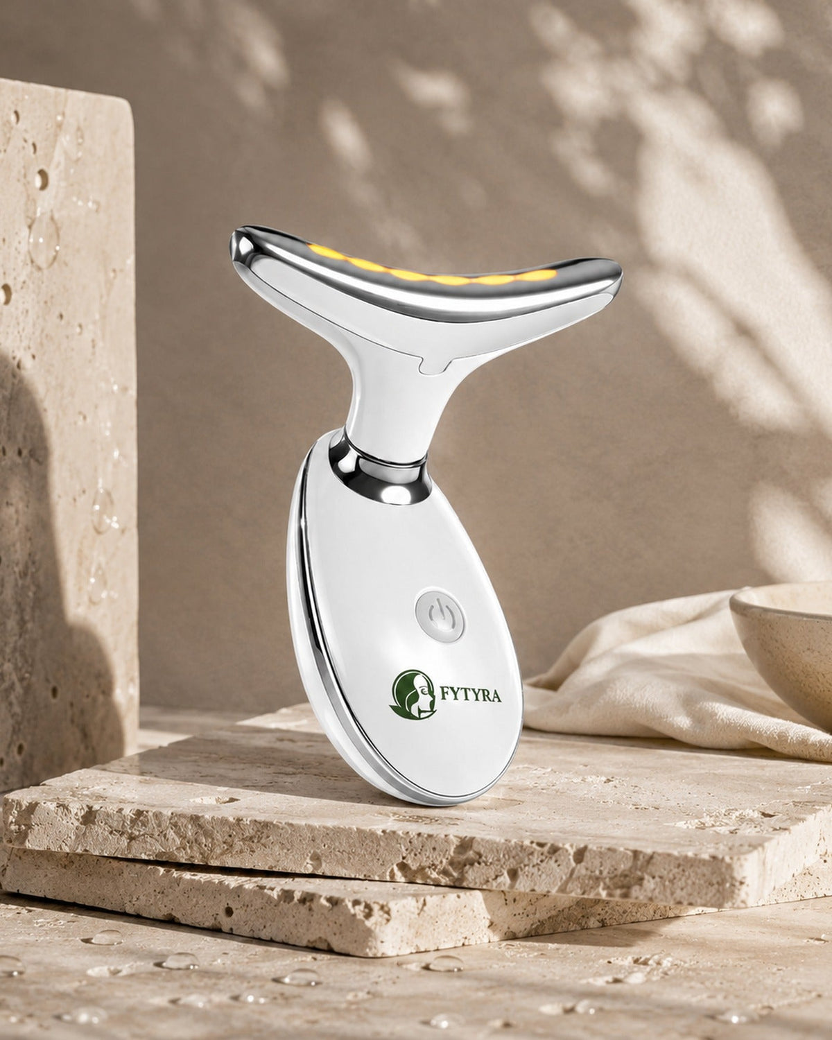 The Fytyra Sculpting Device in White on a travertine ledge in warm daylight